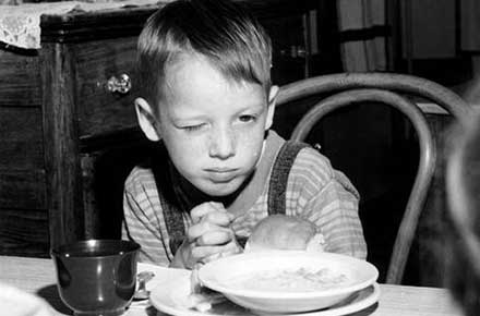 Boy saying prayers before eating