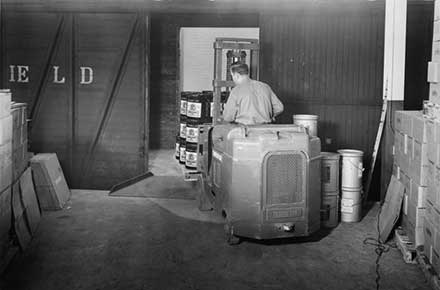 Worker loading train car with forklift at Patterson-Sargent plant, 1946