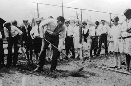 Teacher demonstrates proper hoe technique in a Cleveland Public School tract garden