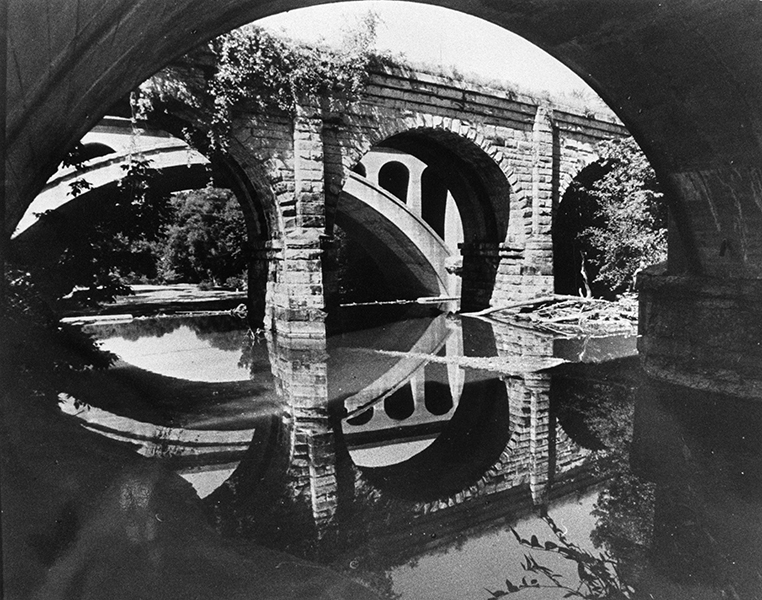 Stone arch bridges span river at Metro Parks, by William Wynne